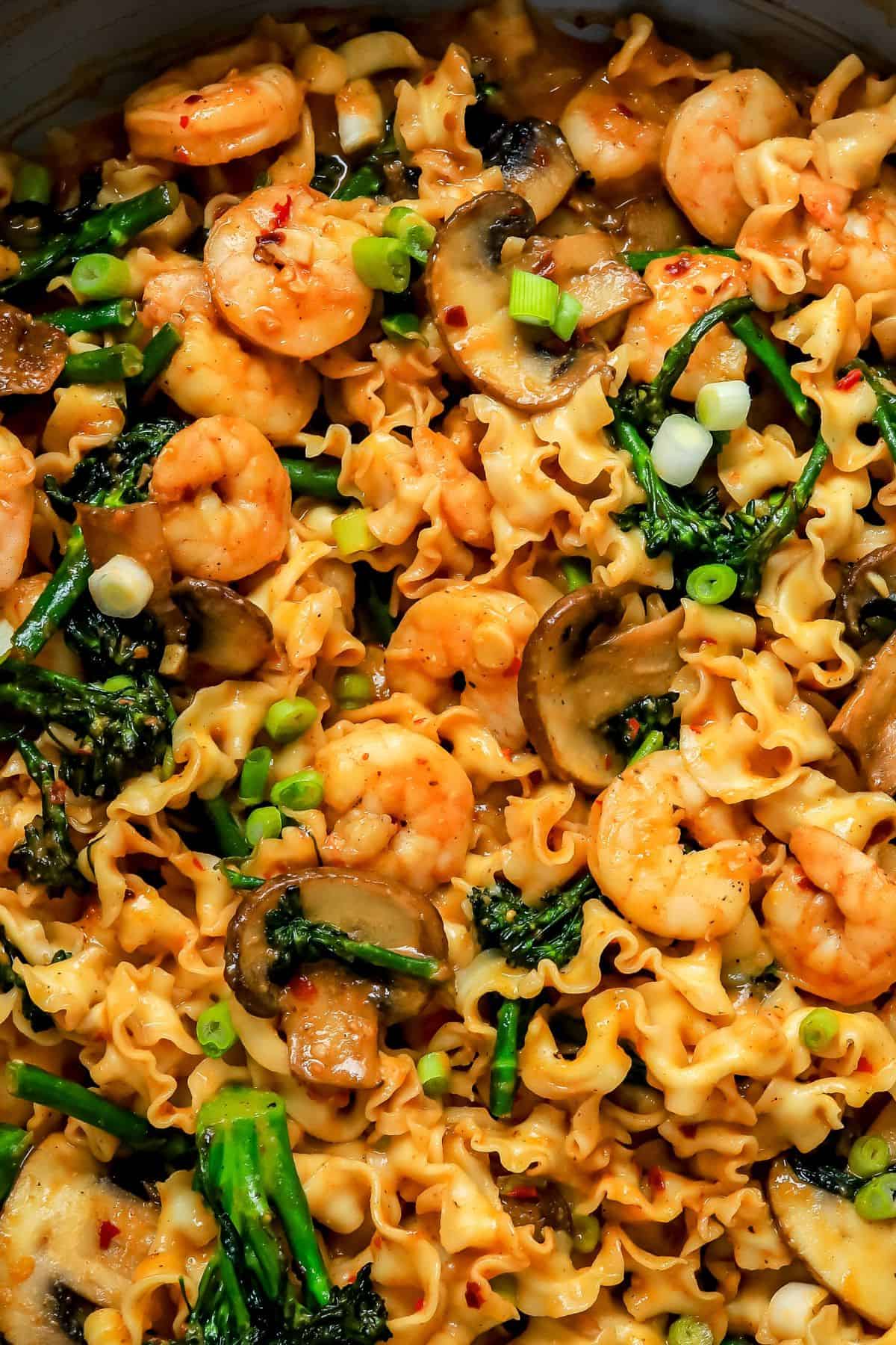 Miso noodles in a skillet with sauce and mushrooms.