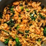miso noodles in a skillet with broccolini and shrimp.