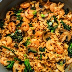 miso noodles in a skillet with broccolini and shrimp.