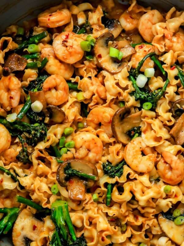 miso noodles in a skillet with broccolini and shrimp.