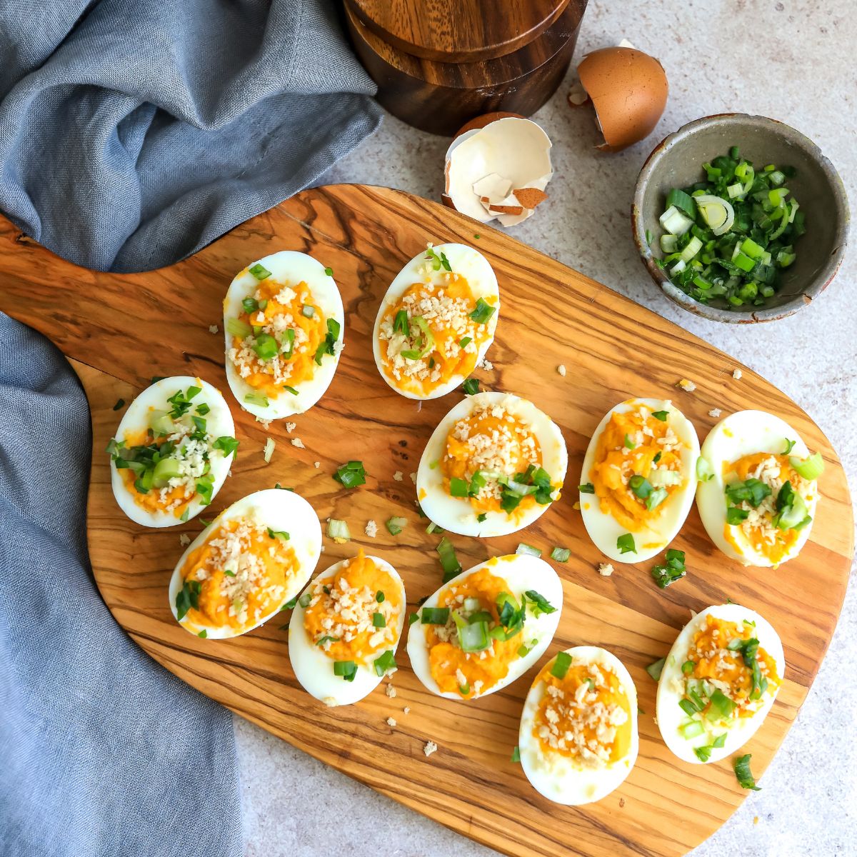 Eggs on a cutting board with green onions. 
