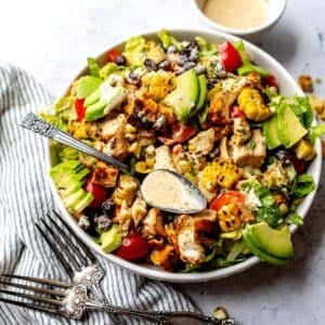 Spicy Southwest Salad in a white bowl on a counter with a towel to the side.