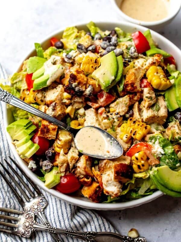 Spicy Southwest Salad in a white bowl on a counter with a towel to the side.