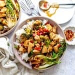 Teriyaki Chicken Rice Bowls on a counter with a plate and a spoon on the side.