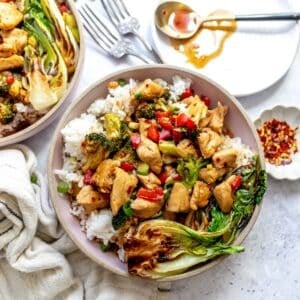 Teriyaki Chicken Rice Bowls on a counter with a plate and a spoon on the side.