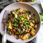 Pink bowl with beef and rice in it.