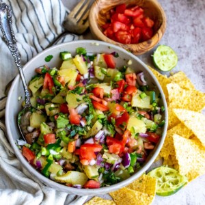 Grey bowl with pineapple, tomatoes, jalapeños and more.