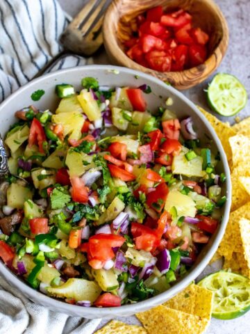Grey bowl with pineapple, tomatoes, jalapeños and more.