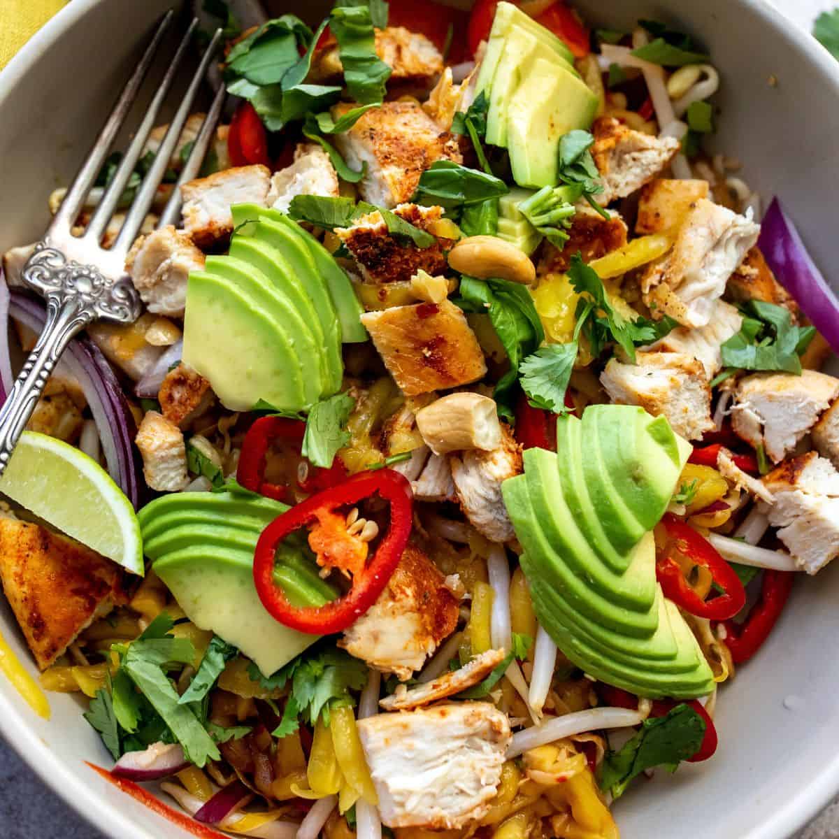 Thai mango salad up close in a white bowl. 