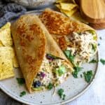 Wraps with chicken salad on a plate with chips.