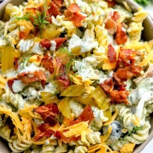 Bowl with Dill Pickle Pasta Salad in it and dill to the side.
