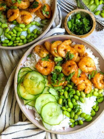 Two bowls with rice and shrimp in it.