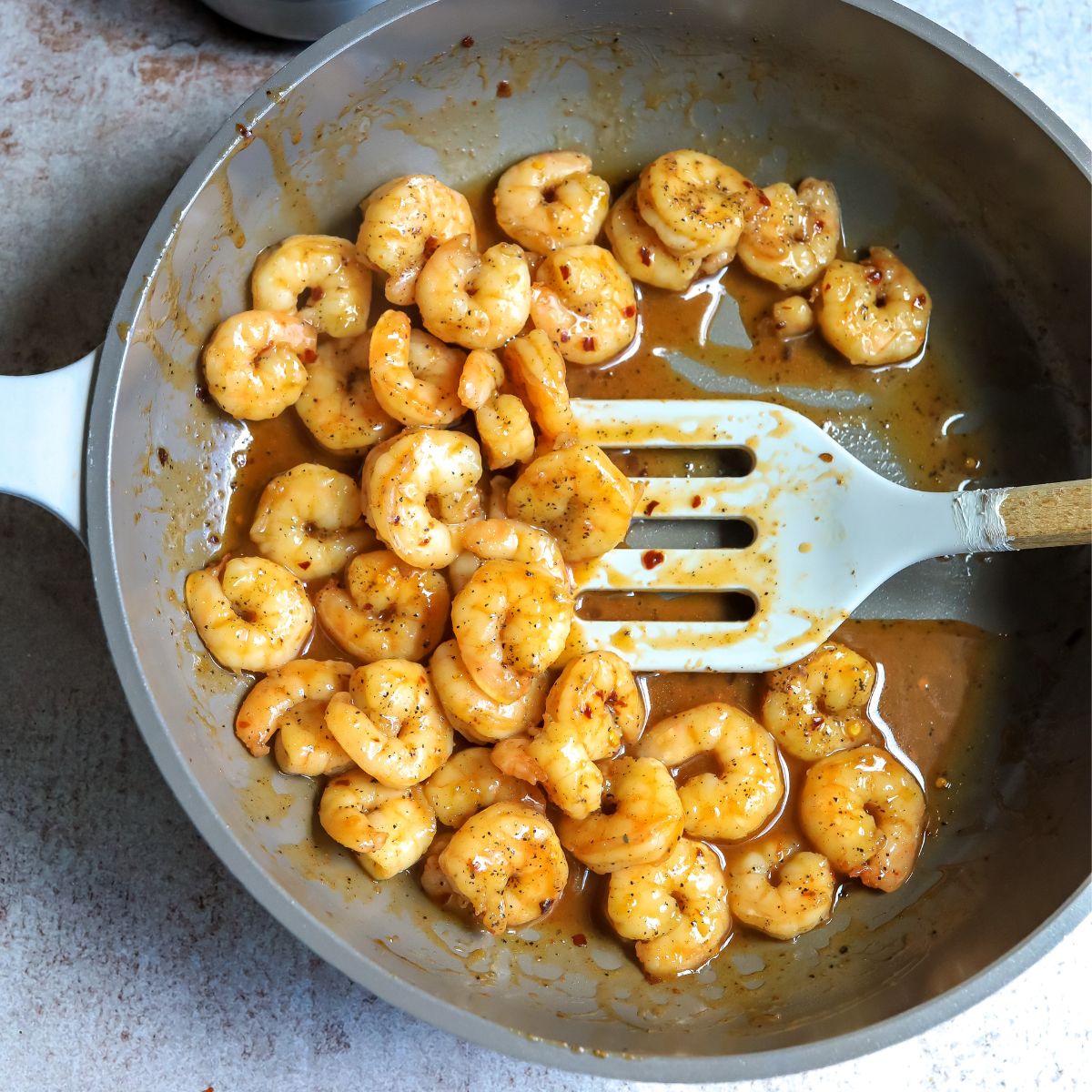 Cooked shrimp in sauce in a skillet. 