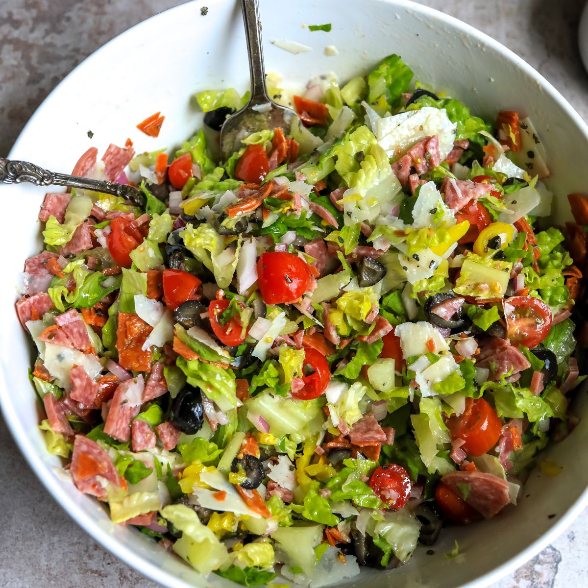 Chopped salad with ingredients in a white bowl. 