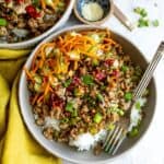 Ground turkey with sauce and veggies in a grey bowl.