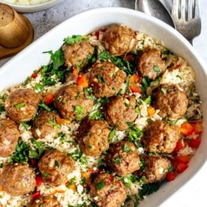 Meatballs and rice in an oval casserole dish on a countertop.