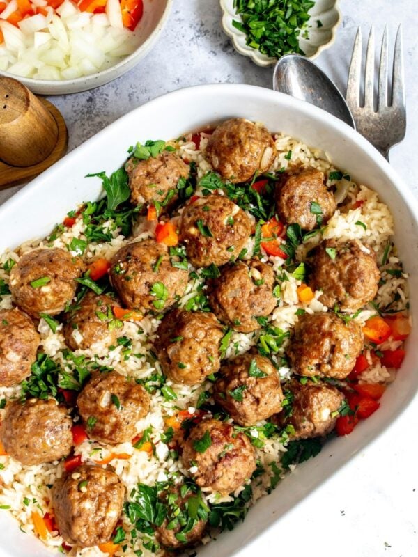 Meatballs and rice in an oval casserole dish on a countertop.