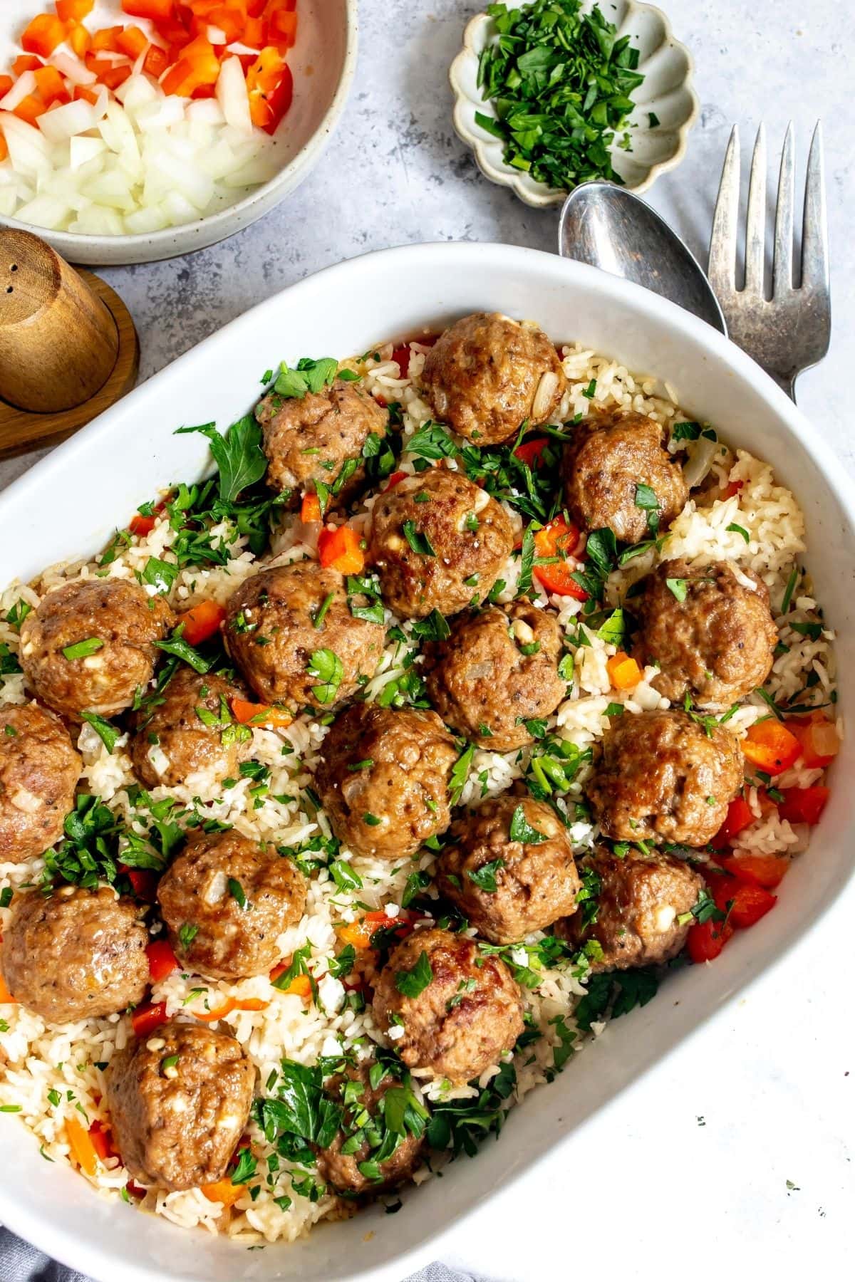 Meatballs and rice in an oval casserole dish on a countertop.