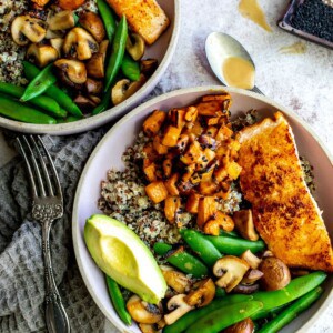 Two bowls with salmon, fresh veggies and quinoa.
