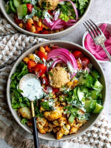 Gray bowls with spiced veggies and tzatziki sauce