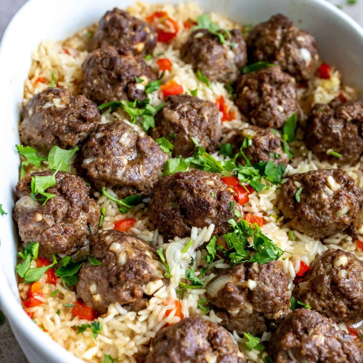 Meatballs up close in rice and in a casserole dish.