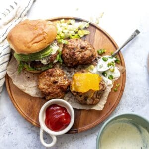 Turkey Burgers on buns on a plate and spoon on the side with jalapeño mayo.