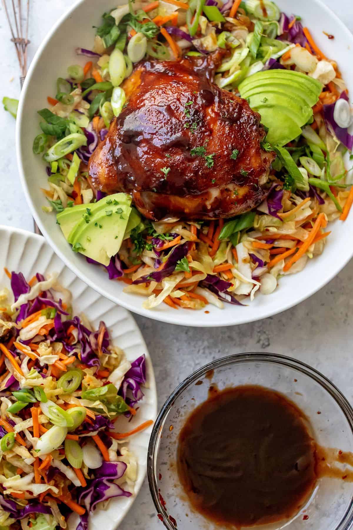Bowl up close with BBQ chicken thighs baked in the oven.
