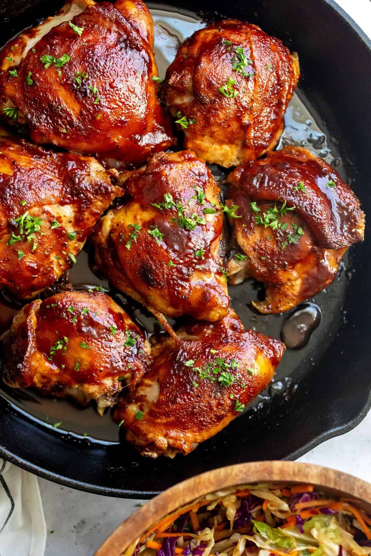 BBQ Baked Chicken Thighs in a cast iron skillet. 