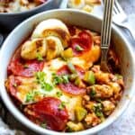 White bowl with ground meat and pepperoni.