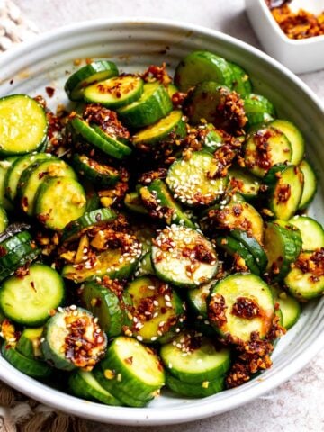 Spicy Cucumber Salad in a white ceramic bowl with spicy crunch.
