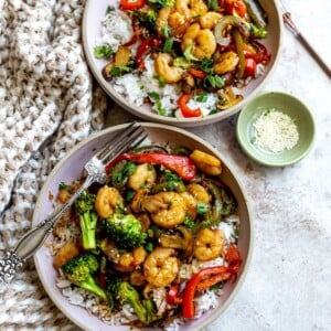 Two pink bowls with shrimp stir fry.
