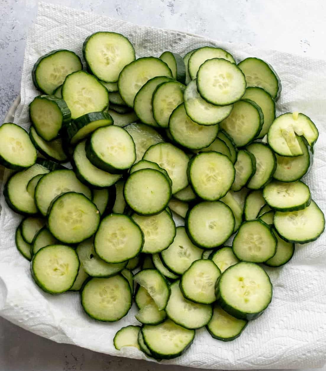 The salted and dried cucumbers on a plate lined with paper towels before mixing the salad.