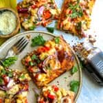 BBQ chicken on flatbread with cilantro and seasoning.