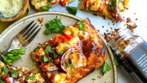 BBQ chicken on flatbread with cilantro and seasoning.