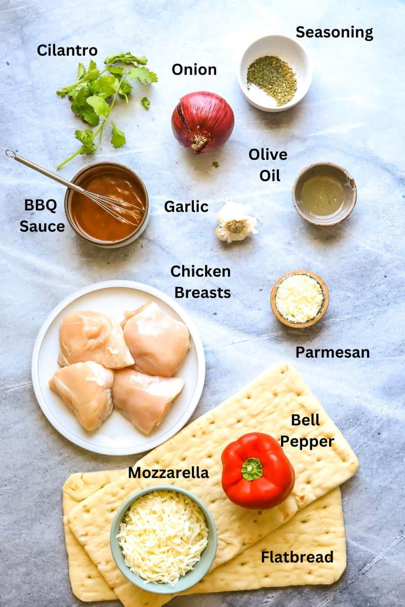 Ingredients needed to make bbq chicken flatbread on a counter in small bowls and on small plates. 