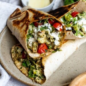 Chicken wraps with pesto and in a wrap on a ceramic plate.
