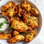 White ceramic bowl with chicken tenders and dipping sauce.