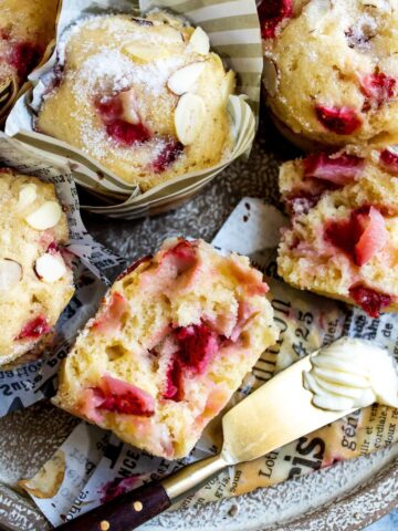 Muffins on a plate with butter and strawberries.