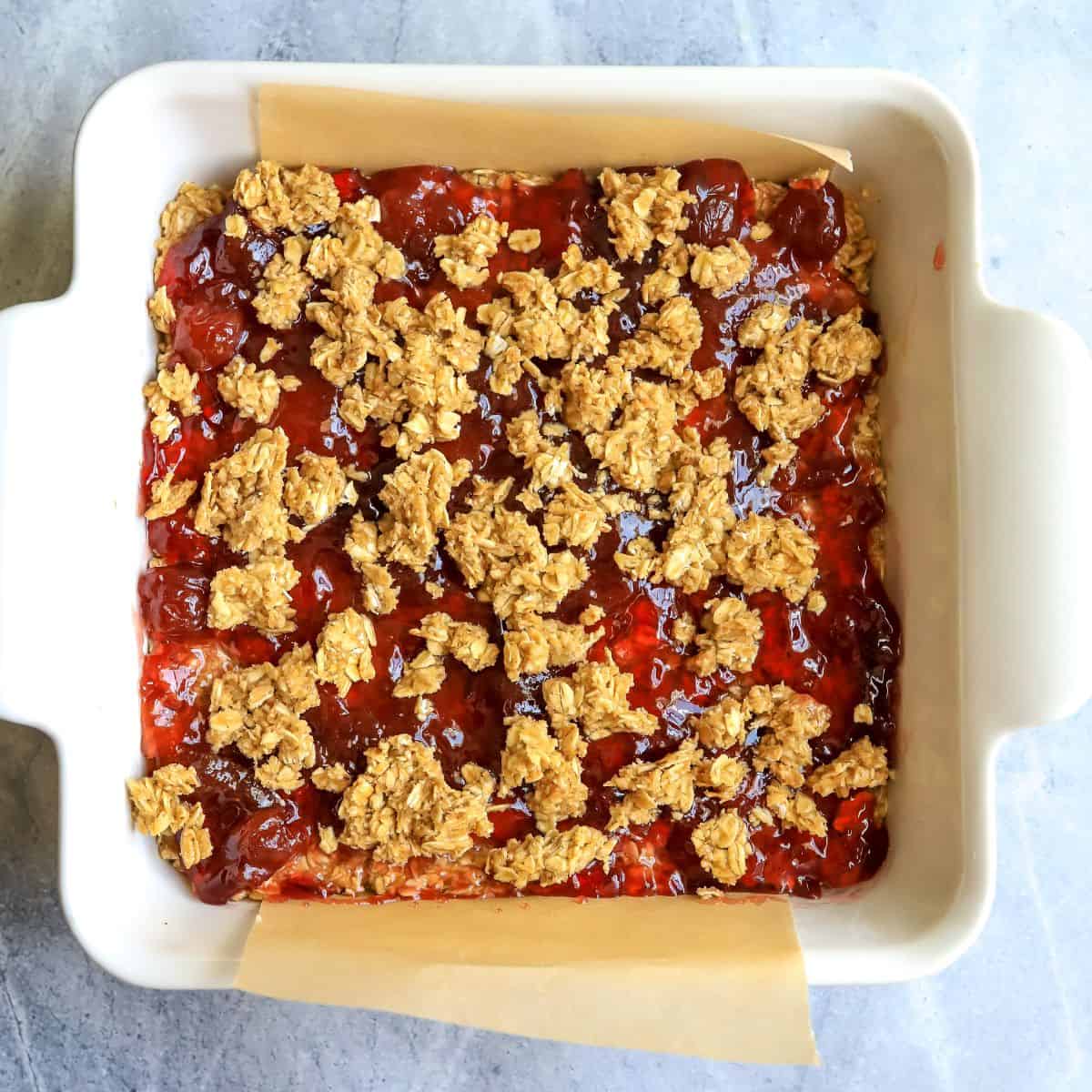 White ceramic baking dish with pbj mixture in it. 