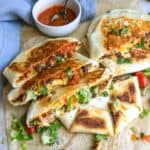 Black bean crunch wraps on parchment on a counter with salsa.