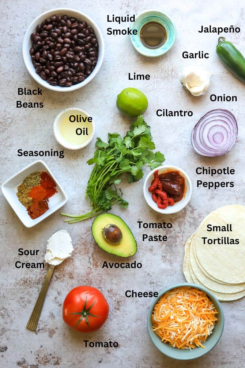 Ingredients needed to make Crispy black bean tacos in small bowls and plates on a counter. 