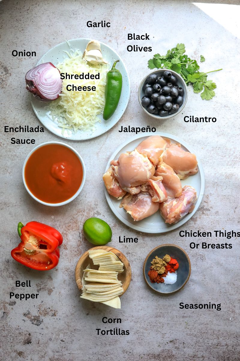 Ingredients needed to make crock pot chicken enchiladas on a counter in small bowls and plates. 