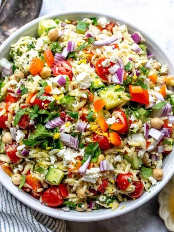 White bowl with close up of Lemon Orzo With feta and almonds.