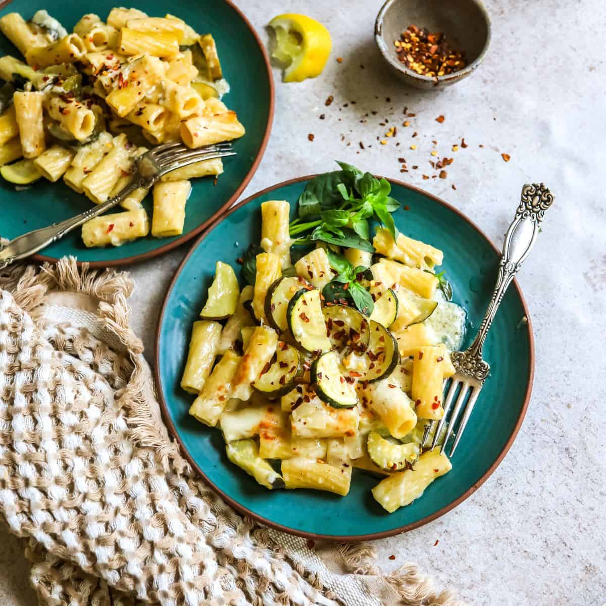 Lemon Pepper Pasta on a green ceramic plate with silver forks. 