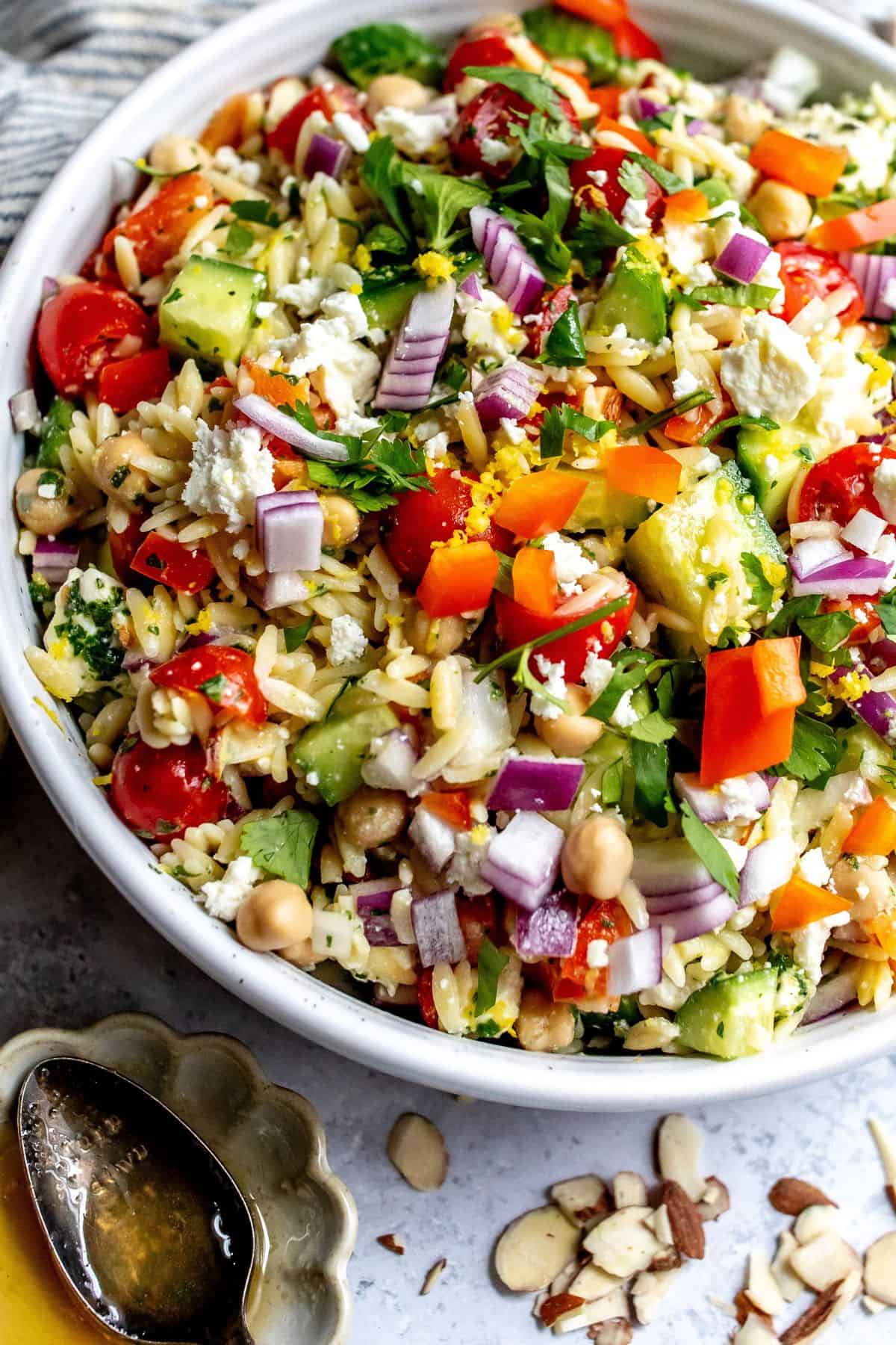 White bowl with close up of Lemon Orzo With feta and almonds.