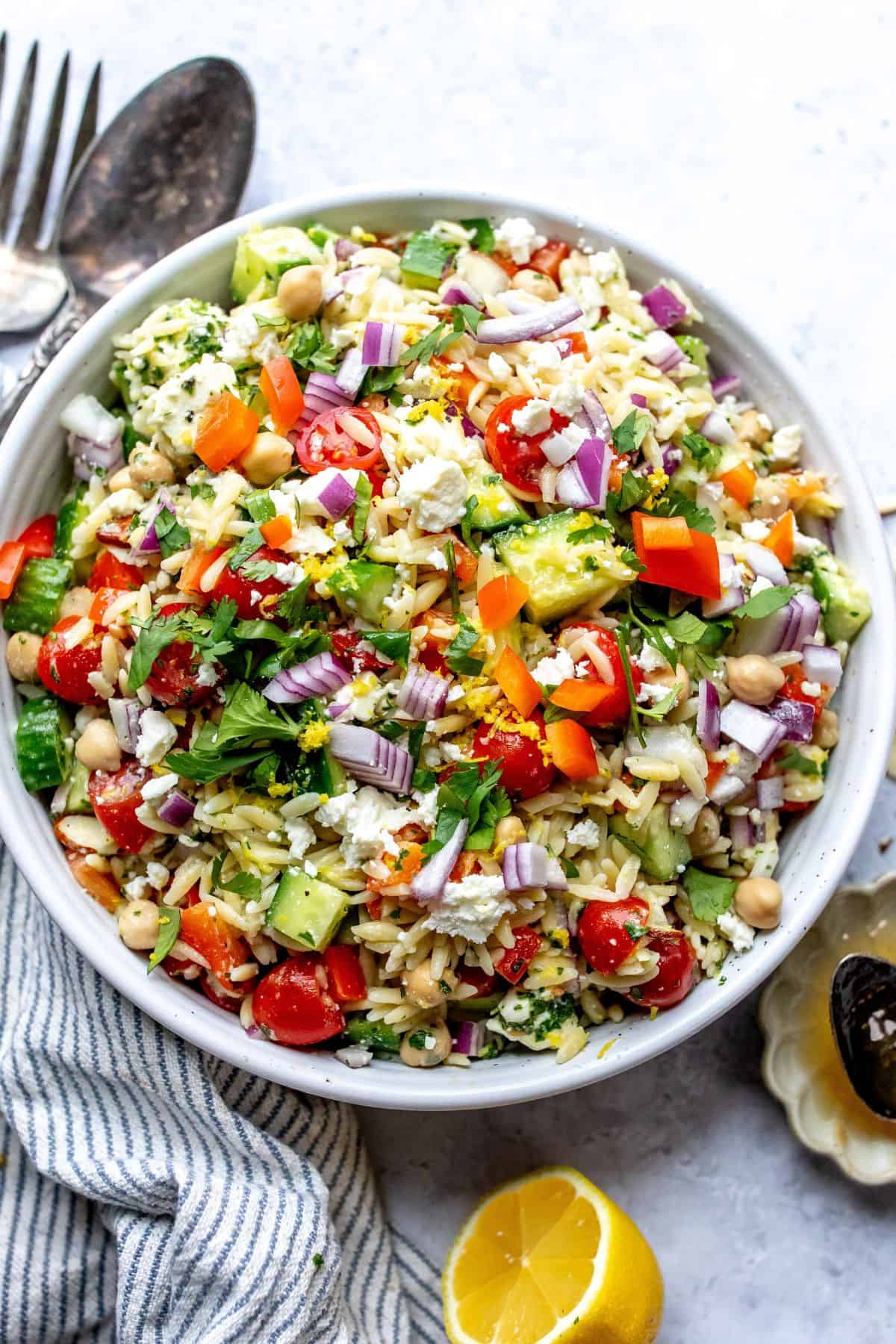 White bowl with close up of Lemon Orzo With feta and almonds.