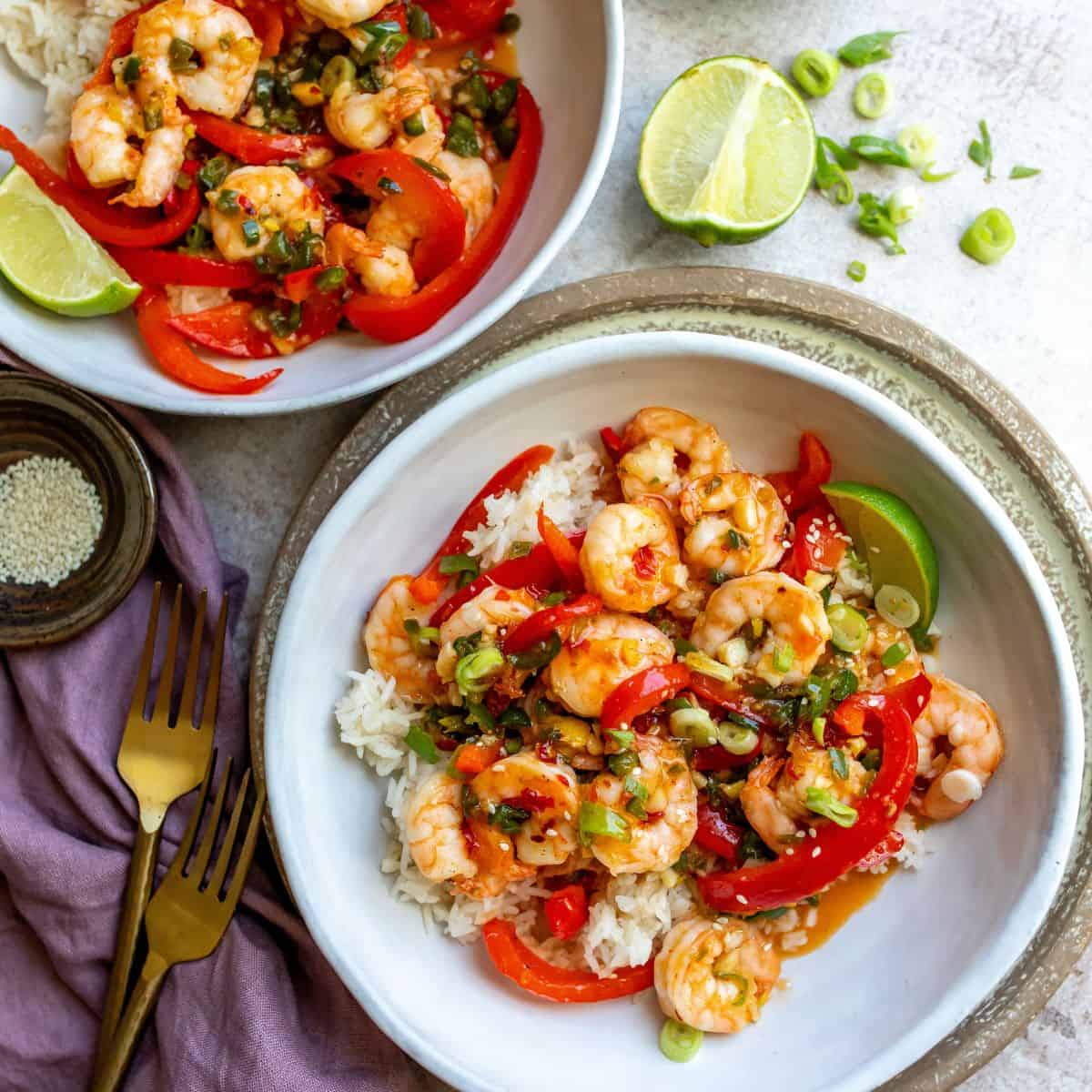 White bowls with shrimp and peppers in them. 