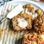 muffins on a white ceramic plate with stripped muffin liners and butter.