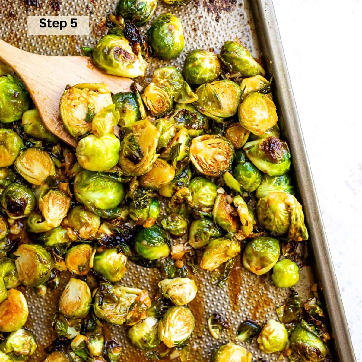 Brussel sprouts on a baking sheet with  sriracha and honey sauce. 
