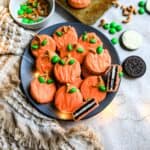 Orange cookies on a grey plate with a tea towel.